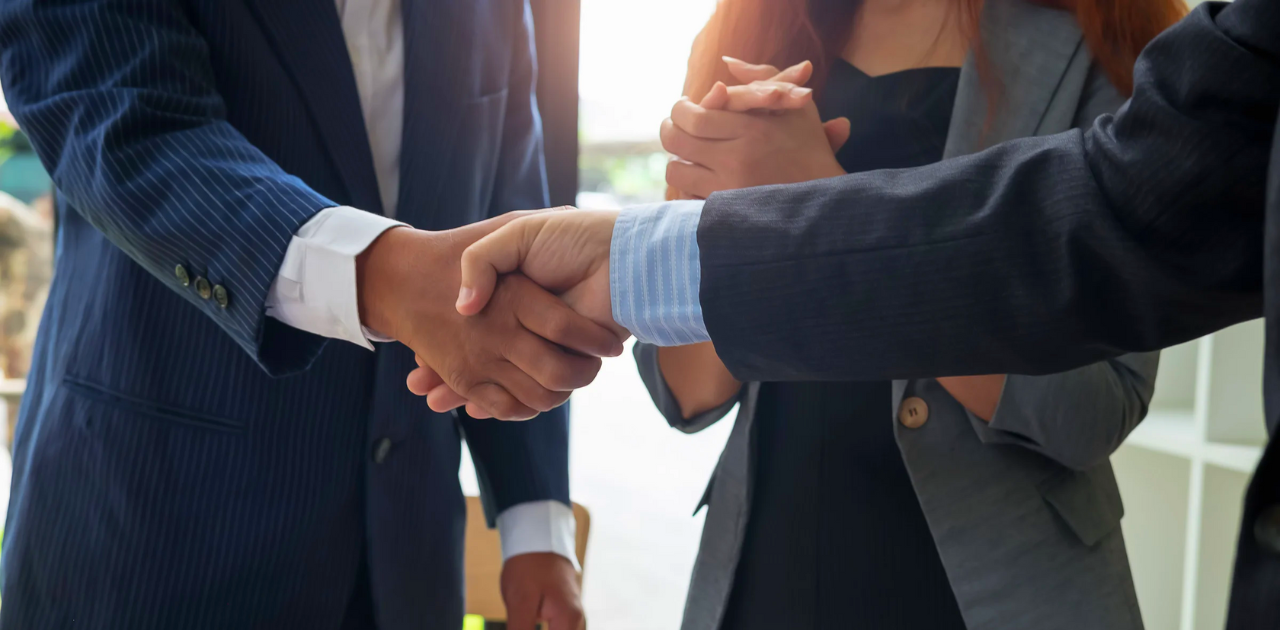Synonym für Kooperation zwischen Startup und Unternehmen: Handschlag zwischen zwei Personen